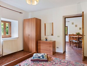A bedroom with a bed, a wardrobe, a dresser, and a window. - Apartment in Fosciandora With Pool (Fosciandora)