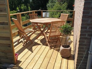 Enjoy meals and relaxation on the deck with a round table and comfortable seating for six.