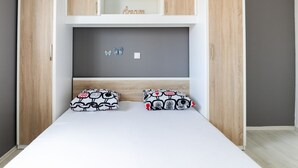A bedroom with a bunk bed, wooden wardrobe, and a grey wall with butterfly decorations. - Comfortable Apartment in Novalja near Zrče Beach  (Novalja)