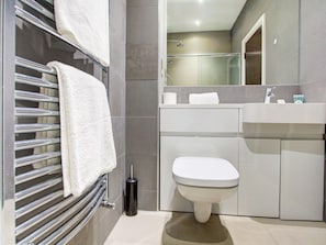 Une salle de bain moderne avec une douche à parois de verre, des toilettes et un lavabo.