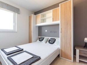 A bedroom with a bed, a bedside table, and a wardrobe with a mirror. - Apartment in Novalja Near Sea Beach (Novalja)