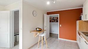 A kitchen with white cabinets, a wooden countertop, and a microwave on top. - Cozy Apartment in Waimes near Ovifat & Robertville Lake (Waimes)