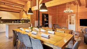 A wooden interior with a dining area, kitchen, and living space. - Elegant Chalet in Manhay With Sauna (Manhay)