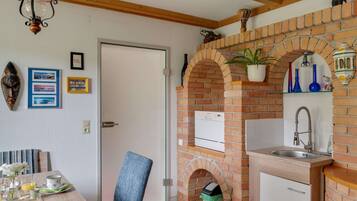 Una cocina con arco de ladrillo, un fregadero y un refrigerador.