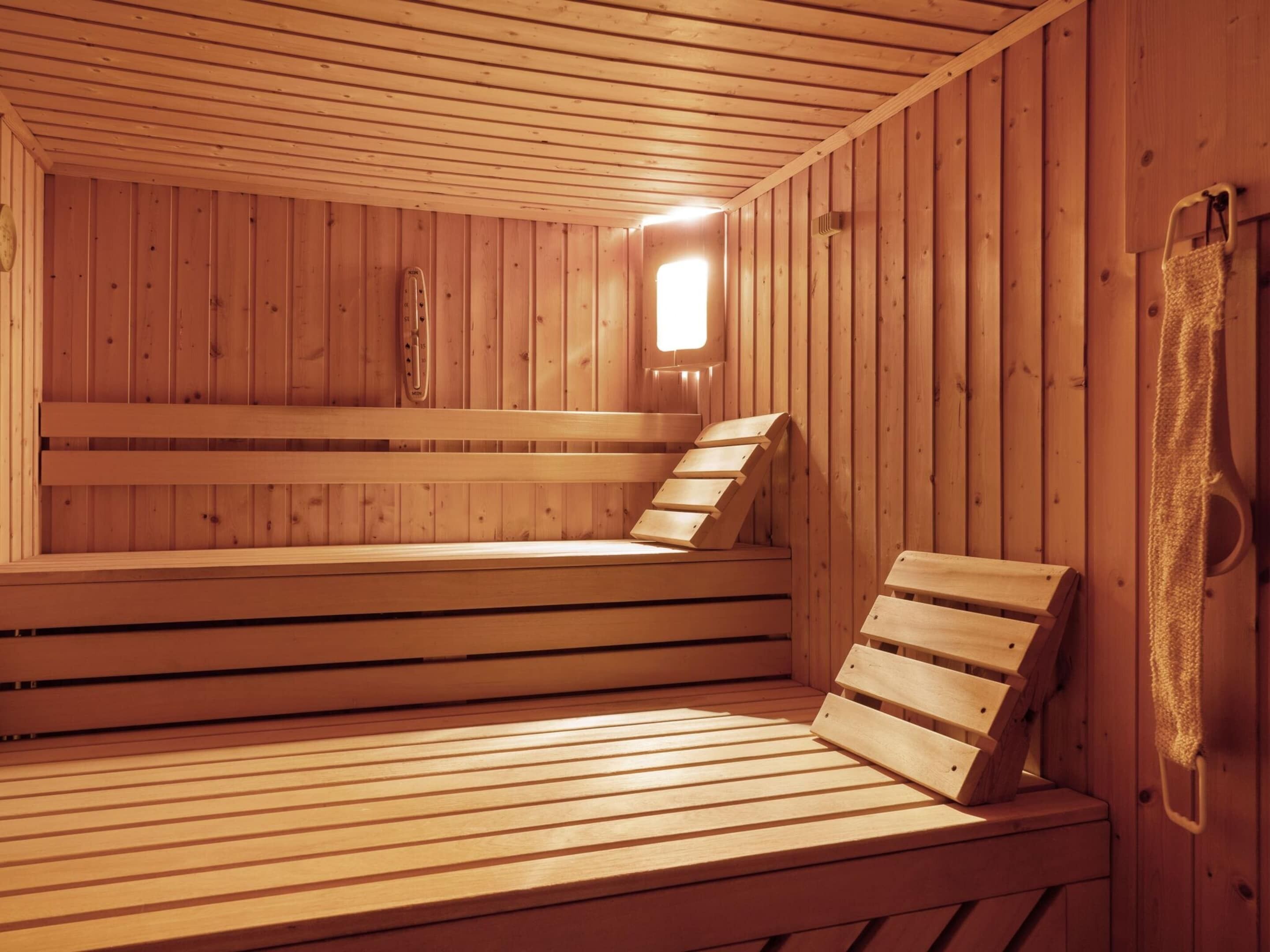 A sauna with wooden benches and a small window.