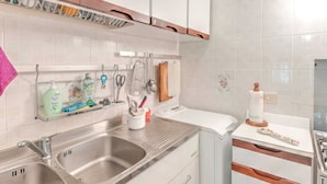 A modern kitchen with stainless steel appliances, a double sink, and a hanging utensil rack. - Beachside Holiday Home in Punta Ala (Castiglione della Pescaia)