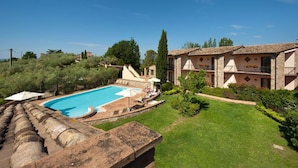 A pool area with a clear blue pool, surrounded by a well-maintained lawn and a stone building with a tiled roof. - Holiday Home in Collazone With Pool & Sauna (Collazzone)