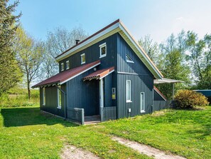 A two-story house with a dark blue exterior, a red roof, and a small front porch. - 5 Person Holiday Home in Hovborg (Hovborg)