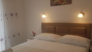 A neatly made bed with two pillows, a headboard, and two bedside lamps.