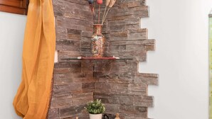 Una pared con diseño de piedra y dos repisas.