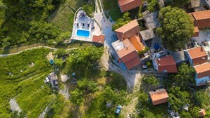 Vue aérienne d’un quartier résidentiel avec des maisons, une piscine et de la végétation environnante.