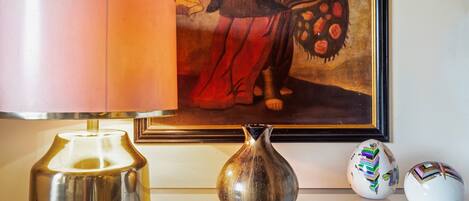 A table with a lamp, a vase, and two decorative items.