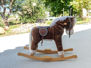 A rocking horse in a park setting.