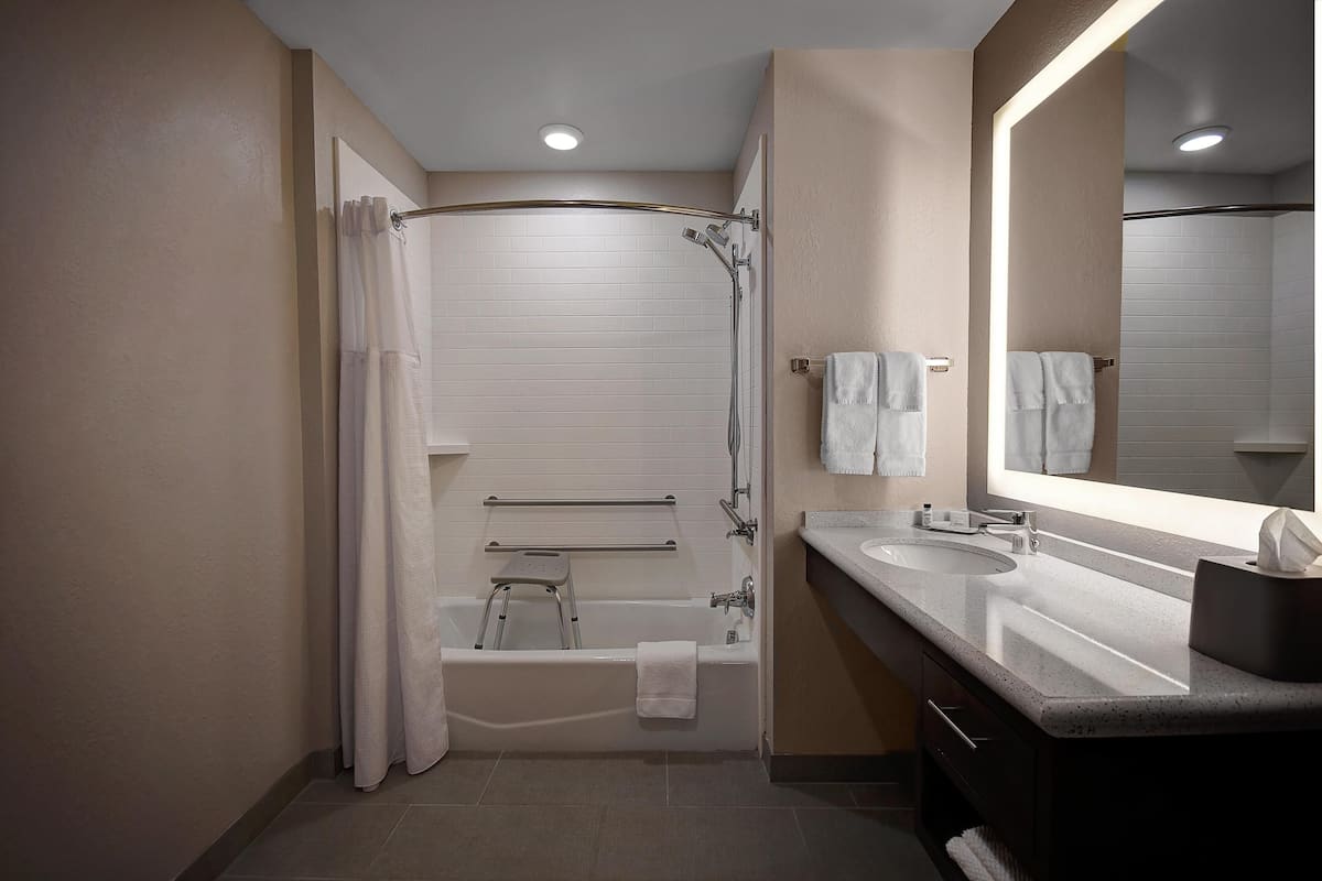 A modern bathroom with a walk-in shower, a bathtub, and a vanity with a mirror.