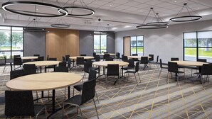 A conference room with round tables, black chairs, and modern pendant lighting. - Holiday Inn St. Louis - Creve Coeur (St. Louis)