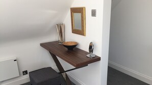 Een moderne badkamer met een houten wastafelmeubel, een spiegel en een handdoekhouder.