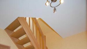 Una escalera de madera con barandilla que conduce a un piso superior.