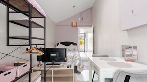 Une chambre à coucher de taille réduite, comprenant un lit, une table de chevet, une télévision et une armoire.
