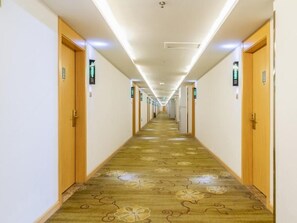 A hotel corridor with wooden doors, carpeted flooring, and overhead lighting. - Greentree Alliance Liaocheng Dongchangfu District Chenkou Road Liaocheng University Hotel (Liaocheng)