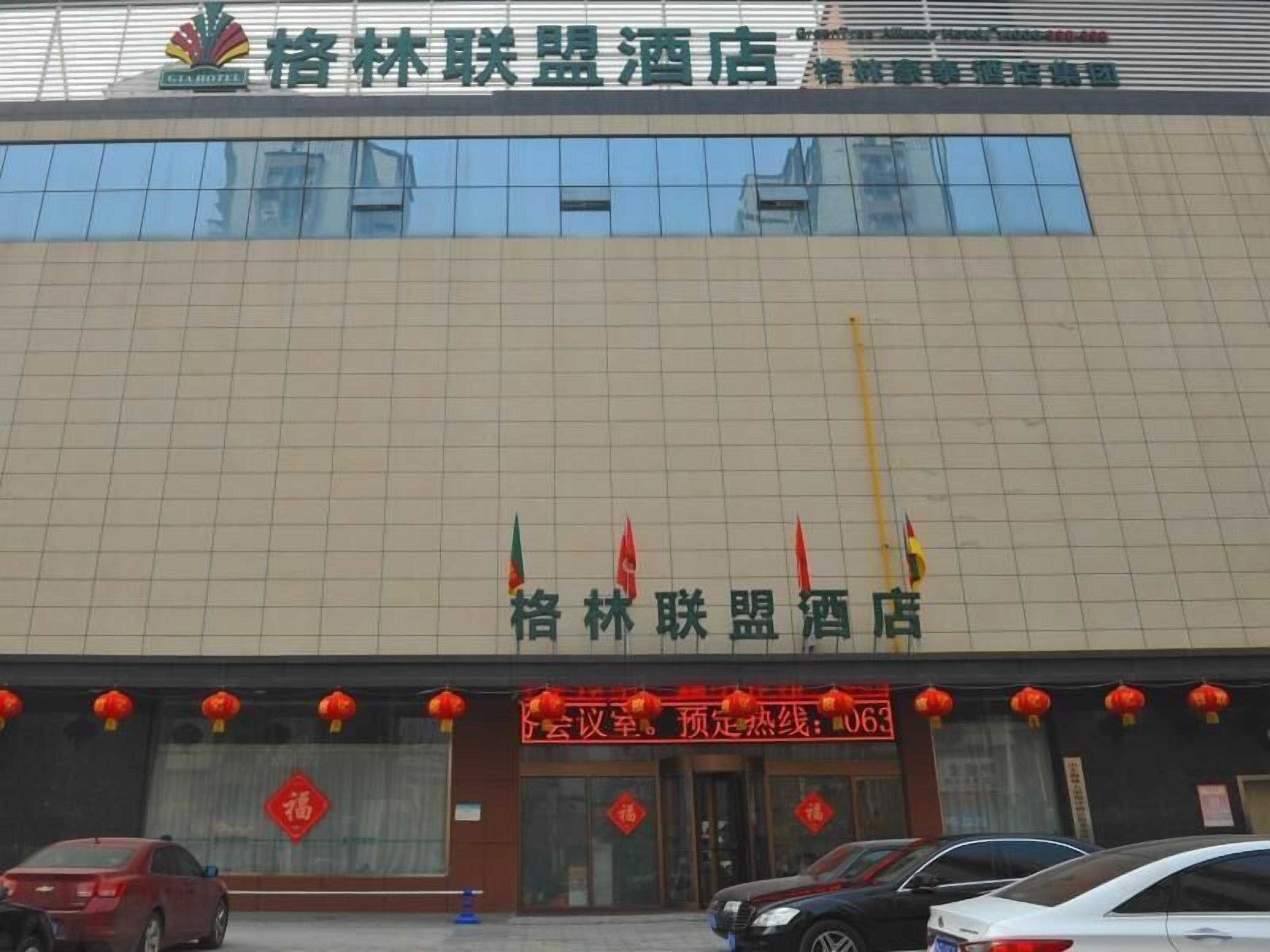 A hotel with a modern facade, featuring a large glass entrance and a prominent sign above the doors.
