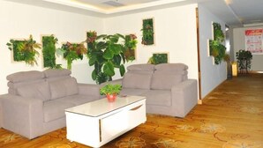 A modern living room with two sofas, a coffee table, and several wall-mounted plants. - Greentree Alliance Liaocheng Dongchangfu District Chenkou Road Liaocheng University Hotel (Liaocheng)