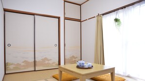 A traditional Japanese room with tatami flooring, a low table with a tea set, sliding doors with a view of the sky, and a hanging plant. - 9//122dk/// (江戸川区)