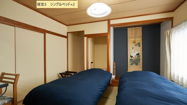 A room with two beds, a desk, and a chair. - BBQ (千歳市白樺)