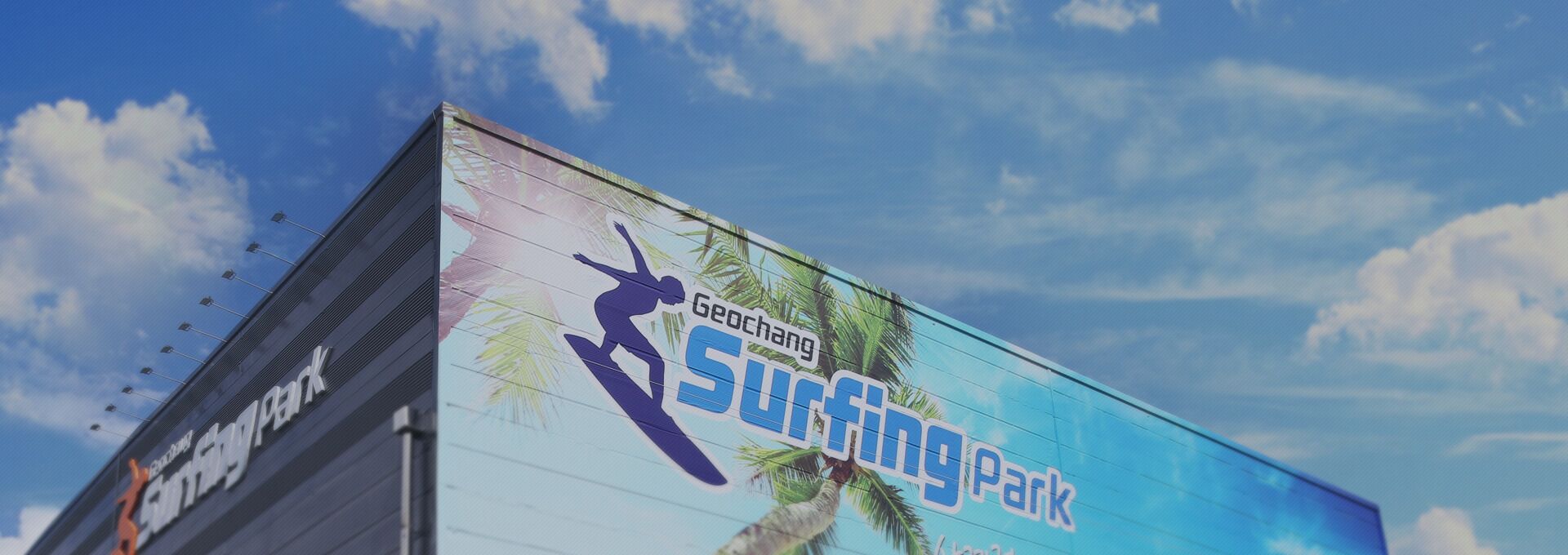 A building with a large outdoor advertisement for a surfing park.