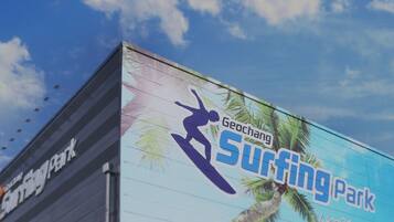 A building with a large outdoor advertisement for a surfing park.