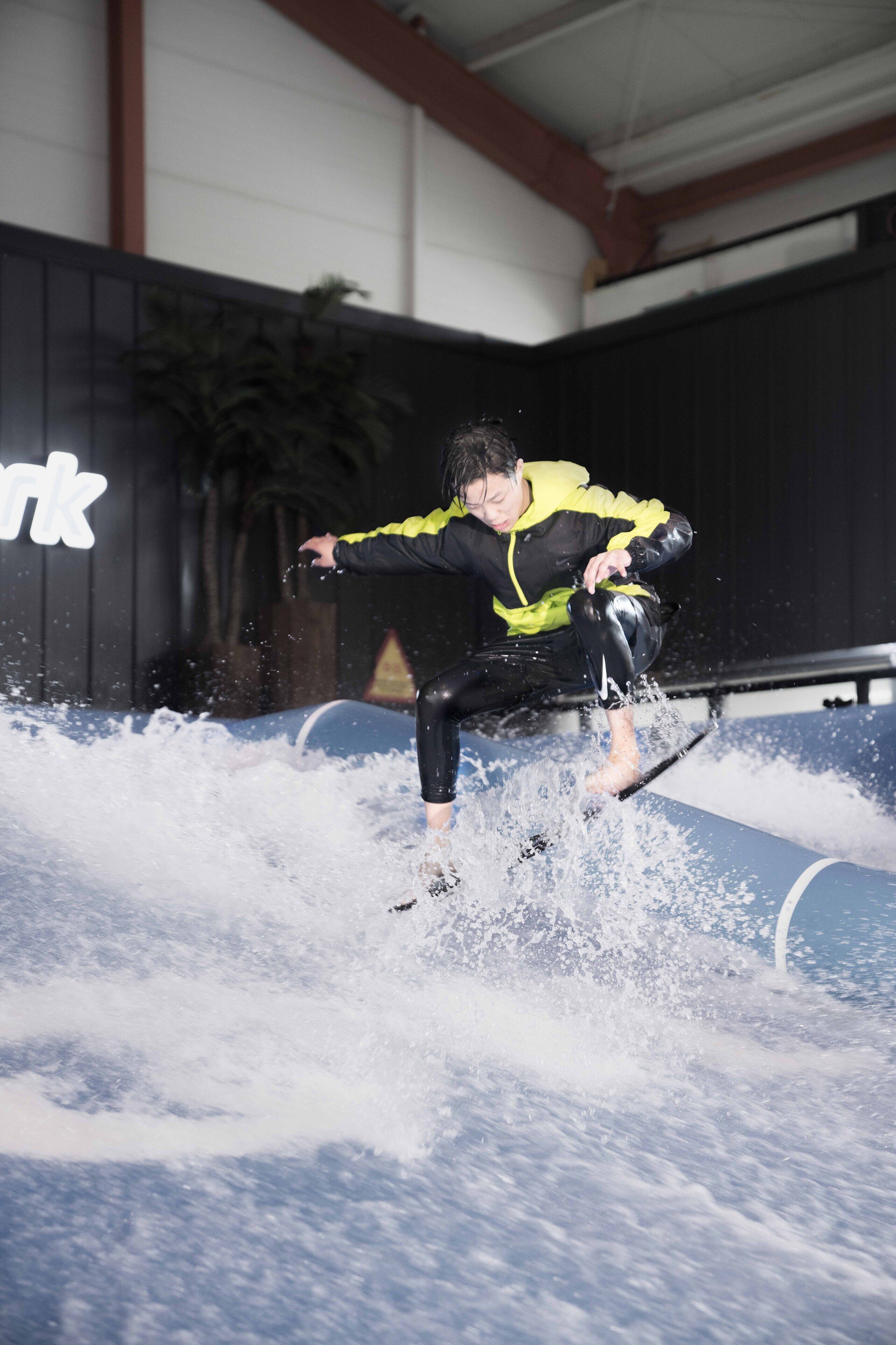 Une personne qui fait de la planche à vagues sur une vague dans un espace intérieur.
