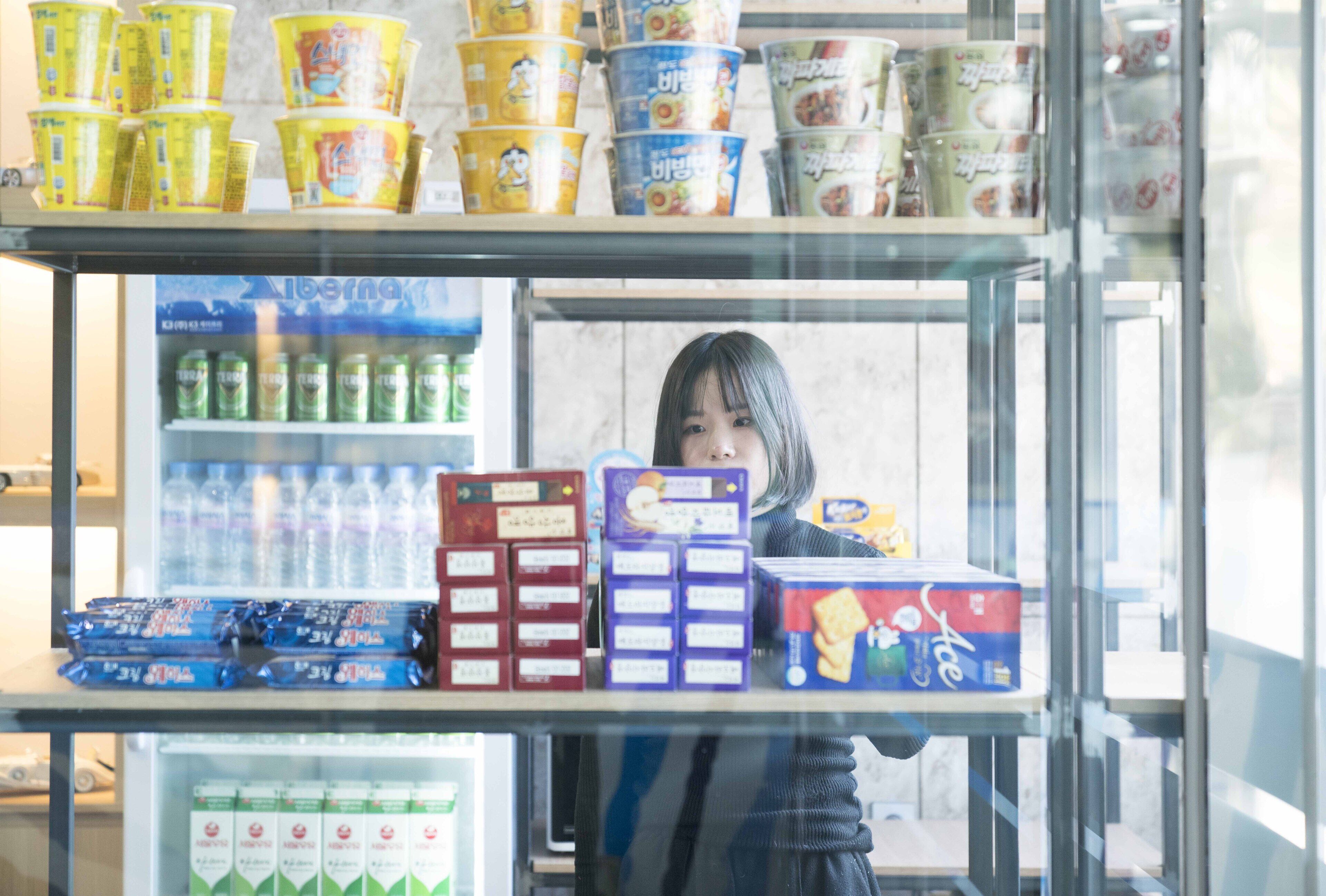 A refrigerated display case with various packaged food items, including beverages and snacks.