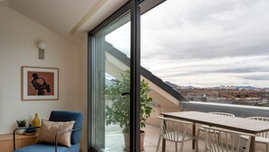 A modern living room with a large sliding glass door leading to an outdoor terrace. - Aparthotel Libere Vitoria (Vitoria-Gasteiz)