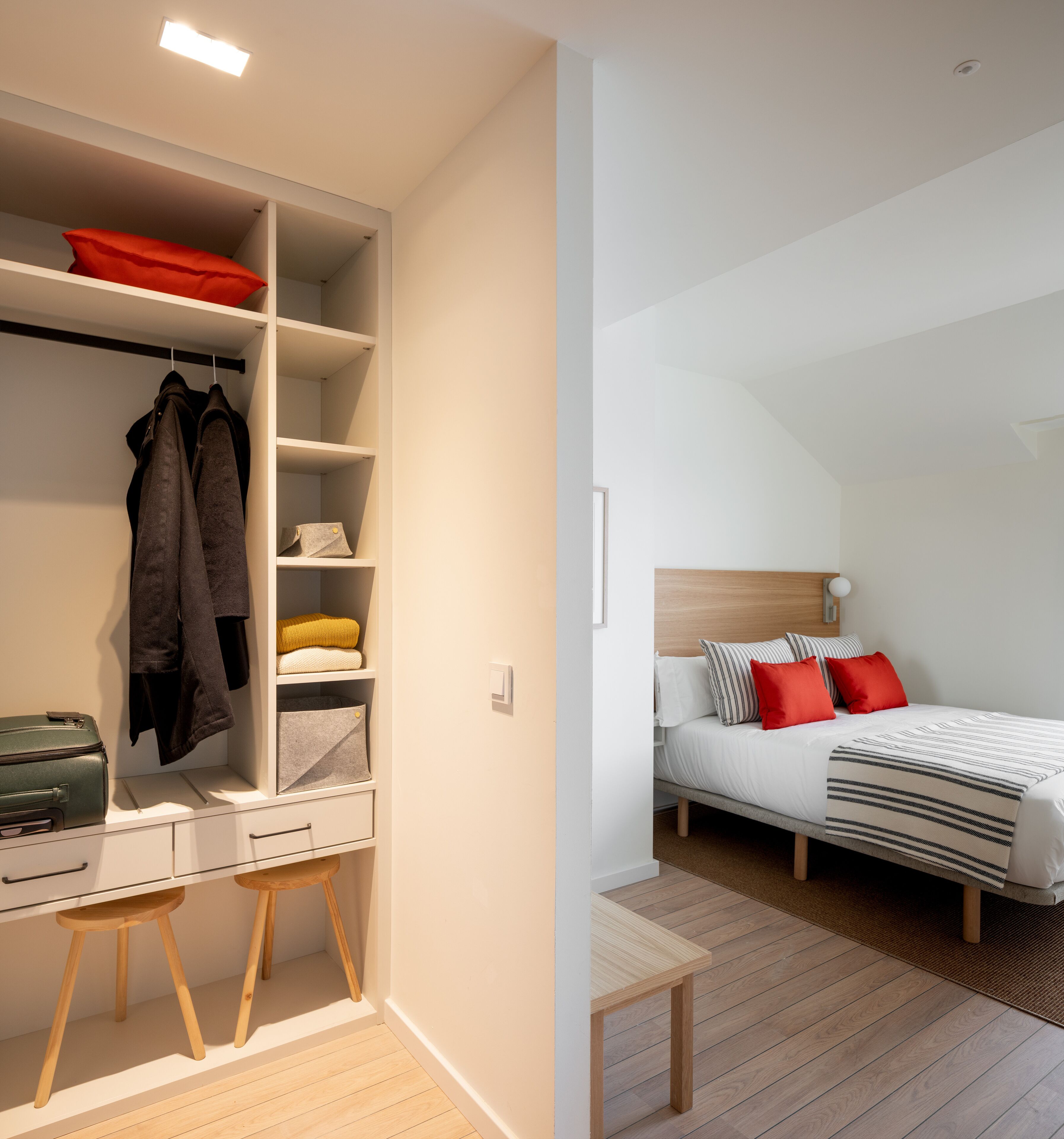 A bedroom with a bed, pillows, and a bedside table.