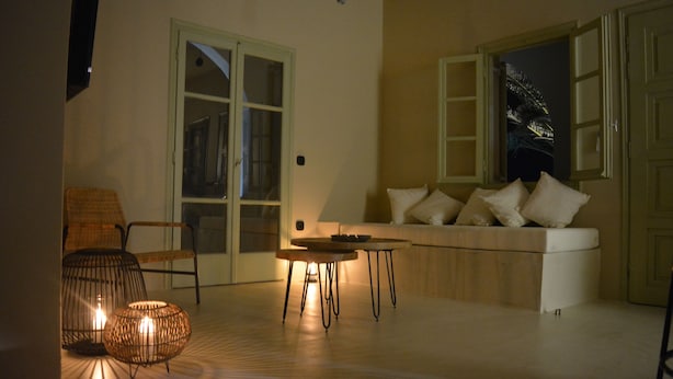 A cozy living room with a sofa, two tables, and a chair.