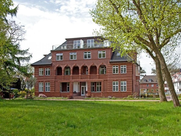 A large, red brick building with multiple windows and a prominent entrance.