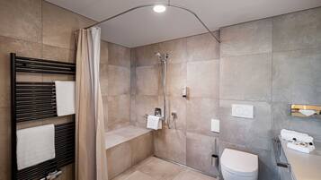 A modern bathroom with a shower, toilet, and towel rack.