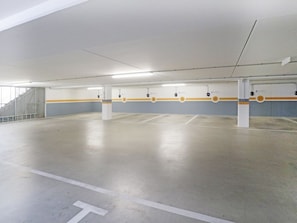 Eine überdachte Parkgarage mit mehreren Stellplätzen, die mit Nummern und weißen Linien gekennzeichnet sind.