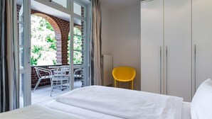 Un dormitorio con una cama, un sillón amarillo y un armario.