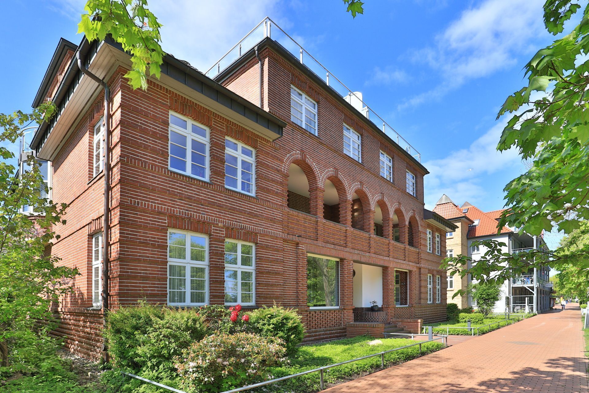 A multi-story brick building with large windows and a central entrance.