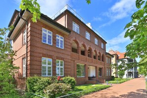 Useita kerroksia sisältävä tiilirakennus, jossa on suuret ikkunat ja keskeinen sisäänkäynti.