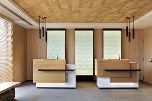 A reception area with wooden panel walls, two reception desks, and a large window with a view. - Fairfield by Marriott Kyoto Amanohashidate (Miyazu)
