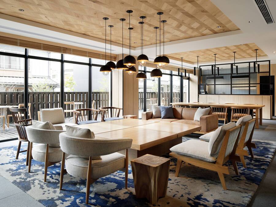 Un comedor amplio con una larga mesa de madera, varias sillas e iluminación colgante.