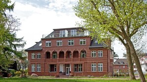 A large, red brick building with multiple windows and a prominent entrance. - Villa Höger Whg. 06, Deutschland (Ostseebad Boltenhagen)