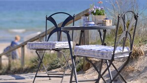 A beachside table with chairs, a small table, and a potted plant. - Villa Höger Whg. 06, Deutschland (Ostseebad Boltenhagen)
