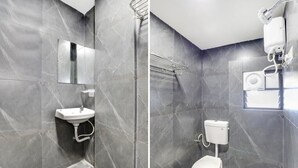 A modern bathroom with grey marble tiles, a white sink, a toilet, and a shower area. - Hotel Govindam by Sky Stays (Ahmedabad)