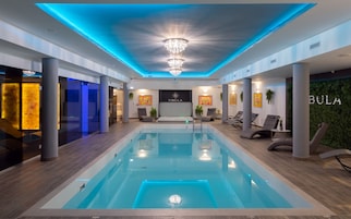 Una piscina techada, sillones reclinables de piscina