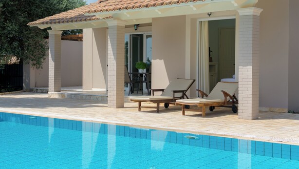 A poolside area with lounge chairs and a covered patio.