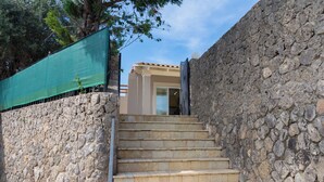 A stone staircase leading to a building with a tiled roof.
