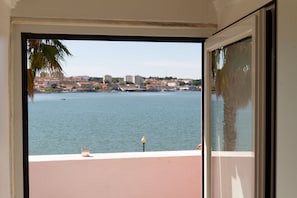 A view from a window overlooking a body of water with buildings in the distance.