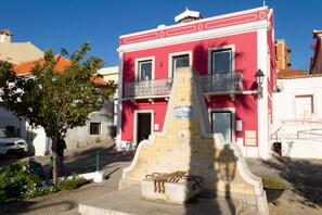A red building with a tiled facade and a balcony. - Loft with terrace and river view in Seixal. Air conditioning. Ideal for 2pax. (Seixal)